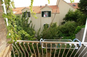 Z balkóna je výhľad na záhradu a dom v susedstve